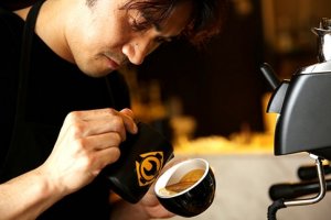 Barista trainer Masa Aoki demonstrates how free pour latte art is done. — Picture by Choo Choy May
